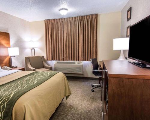a hotel room with a bed and a desk with a television at Quality Inn Lewiston in Lewiston