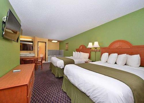 een hotelkamer met twee bedden en een bureau bij Quality Inn & Suites Grinnell near University in Grinnell