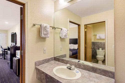a bathroom with a sink and a toilet and a mirror at Rodeway Inn Coeur d'Alene in Coeur d'Alene