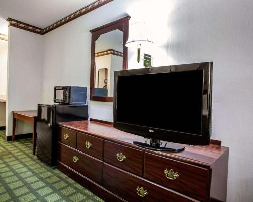 a room with a flat screen tv on a dresser at Quality Inn Arcola in Arcola