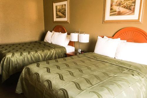 a hotel room with two beds next to each other at Quality Inn & Suites Lincoln near I-55 in Lincoln