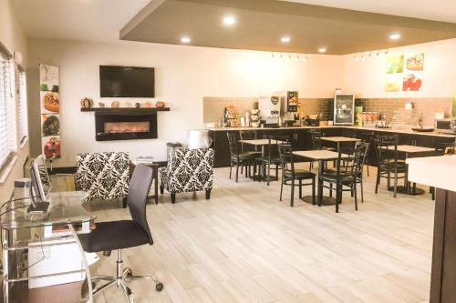 un restaurante con mesas y sillas y un bar en Quality Inn & Suites Lincoln near I-55, en Lincoln