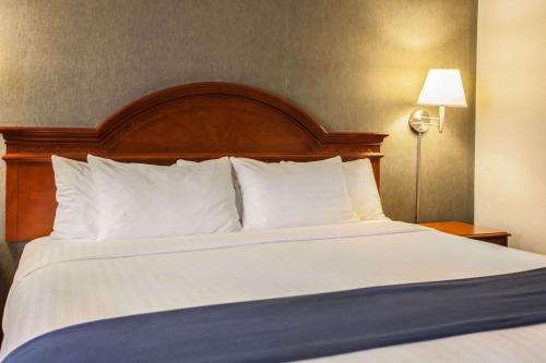 a large bed with white sheets and pillows in a hotel room at Quality Inn & Suites St Charles -West Chicago in Saint Charles