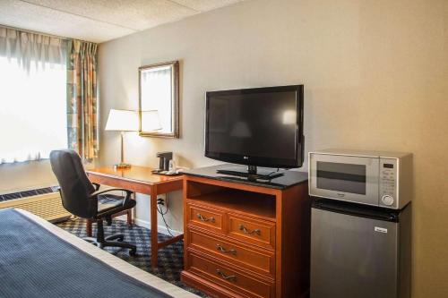 a hotel room with a television and a desk with a bed at Quality Inn & Suites St Charles -West Chicago in Saint Charles