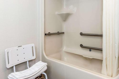 a bathroom with a bath tub and a mirror at Sleep Inn Springfield West in Springfield