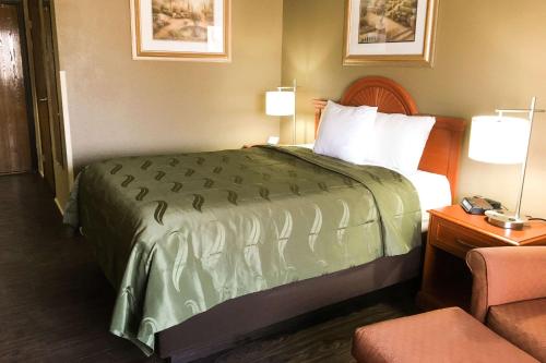 een hotelkamer met een bed en een stoel bij Quality Inn & Suites Lincoln near I-55 in Lincoln