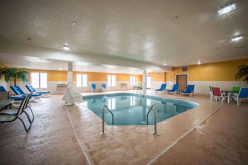 Una gran piscina en una habitación con sillas y mesas. en Quality Inn Litchfield Route 66, en Litchfield