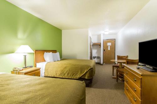a hotel room with two beds and a flat screen tv at Econo Lodge Inn & Suites Pekin - Peoria Area in Pekin