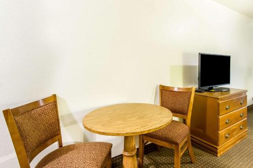 a room with a table and two chairs and a television at Econo Lodge Inn & Suites Pekin - Peoria Area in Pekin