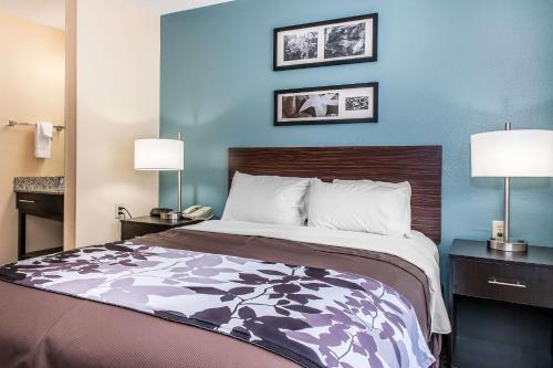 uma cama num quarto de hotel com duas lâmpadas em Sleep Inn Springfield West em Springfield