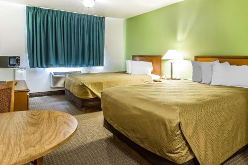 a hotel room with two beds and a table at Econo Lodge Inn & Suites Pekin - Peoria Area in Pekin