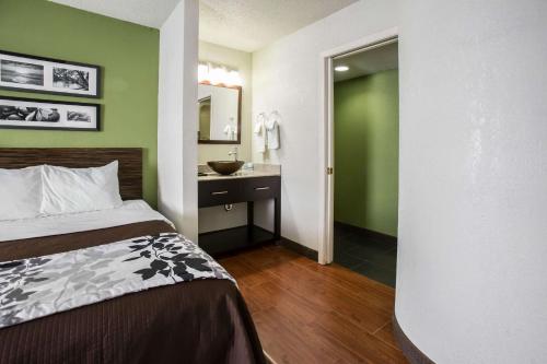 a bedroom with a bed and a bathroom with a sink at Sleep Inn Rockford I-90 in Rockford