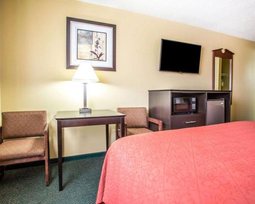 a hotel room with a bed and a desk and a television at Quality Inn Morton at I-74 in Morton