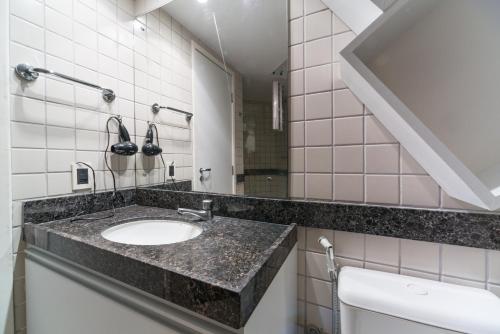 a bathroom with a sink and a mirror at Excelente Flat Beira Mar da praia de Boa Viagem RAD2704 in Recife