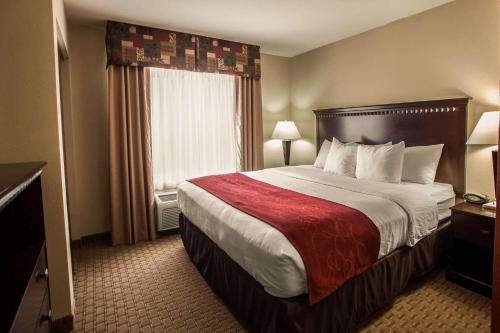 pokój hotelowy z dużym łóżkiem i oknem w obiekcie Comfort Suites Bloomington I-55 and I-74 w mieście Bloomington