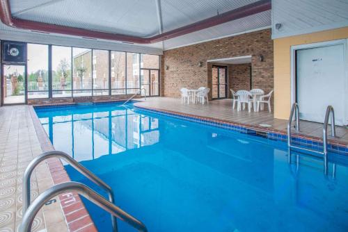 einen Pool mit Tischen und Stühlen in einem Gebäude in der Unterkunft Econo Lodge in Marion