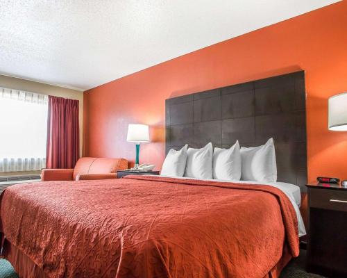 a hotel room with a bed with a red bedspread at Quality Inn Morton at I-74 in Morton