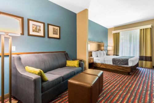 a hotel room with a couch and a bed at Comfort Suites in Fairview Heights