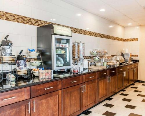 a kitchen with wooden cabinets and a counter top at Quality Inn & Suites Mattoon South in Mattoon
