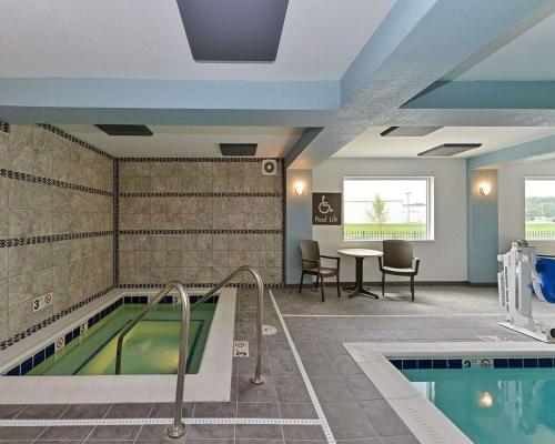 a pool in a room with a table and chairs at Comfort Inn & Suites Springfield I-55 in Springfield