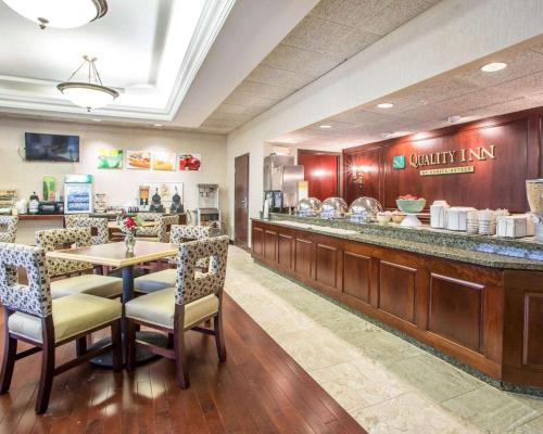 a restaurant with a table and chairs and a counter at Quality Inn Schaumburg - Chicago near the Mall in Schaumburg