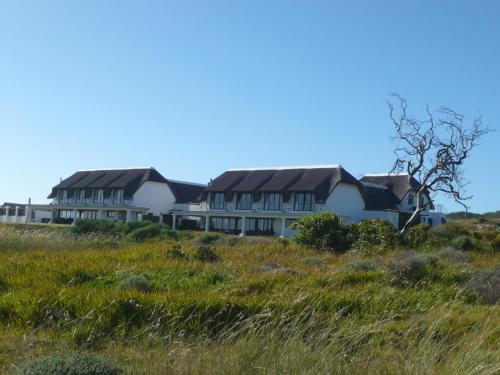 a row of houses on a hill with grass at St Francis Golf Lodge in St Francis Bay