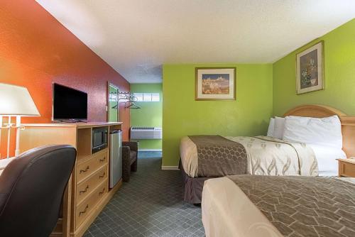 a hotel room with two beds and a flat screen tv at Highway Inn in Paris