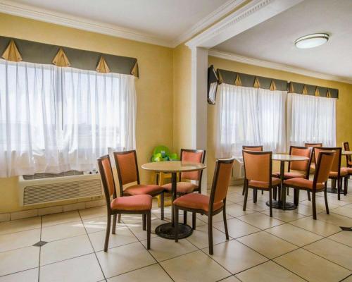 a waiting room with tables and chairs and a window at Quality Inn Evansville Eastland Area in Evansville