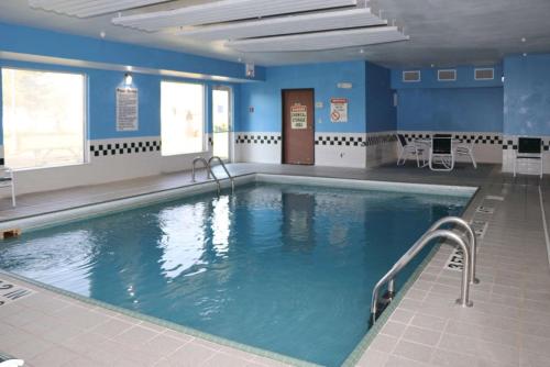 a large swimming pool in a building with blue walls at Quality Inn Evansville Eastland Area in Evansville