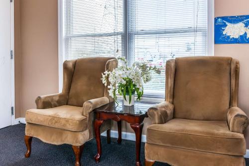 two chairs and a table with a vase of flowers at Econo Lodge Vincennes in Vincennes