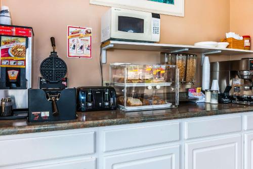 a kitchen with a counter with a microwave and some food at Econo Lodge Vincennes in Vincennes