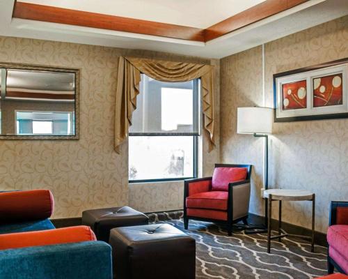 a living room with a red chair and a window at Quality Inn & Suites near St Louis and I-255 in Cahokia