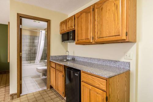 a kitchen with wooden cabinets and a black dishwasher at Quality Inn I-74 Batesville in Batesville