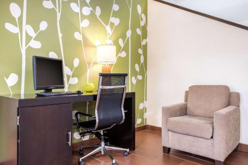 a desk with a computer and a chair in a room at Sleep Inn & Suites Columbus South in Columbus