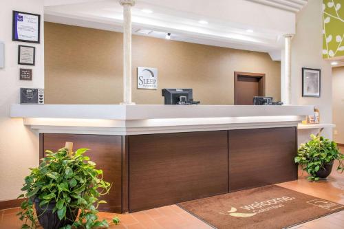 a reception desk in a hospital lobby with plants at Sleep Inn & Suites Columbus South in Columbus
