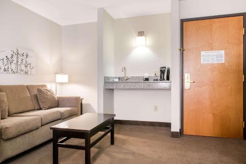 a living room with a couch and a table at Sleep Inn & Suites Columbus in Columbus