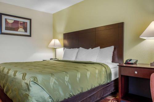 a hotel room with a bed and a telephone at Quality Inn Bloomington Near University in Bloomington