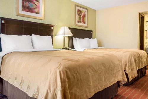 a hotel room with two large beds in it at Quality Inn in Huntingburg