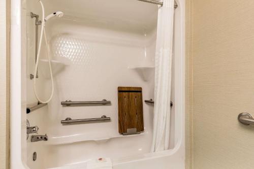 a bathtub with a wooden panel in a bathroom at Comfort Inn & Suites Mishawaka-South Bend in South Bend