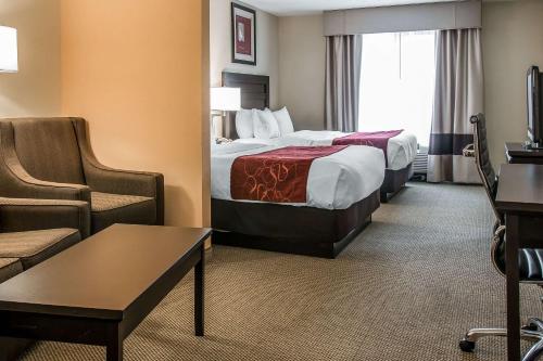 a hotel room with two beds and a chair at Comfort Suites South Bend Near Casino in South Bend