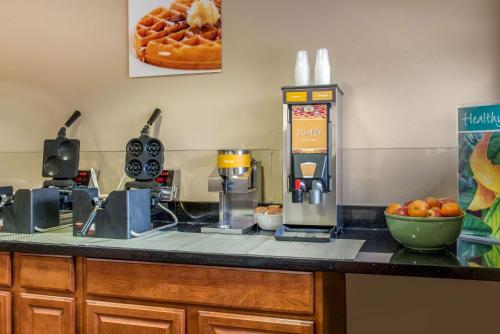 a kitchen counter with a coffee maker and a bowl of oranges at Quality Inn Bloomington Near University in Bloomington