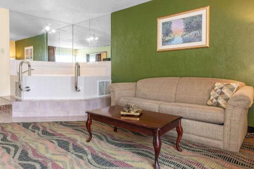 - un salon avec un canapé et une baignoire dans l'établissement Quality Inn Conference Center Logansport, à Logansport