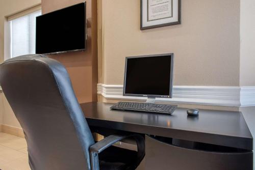 a desk with a computer monitor and a chair at Quality Inn Bloomington Near University in Bloomington