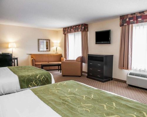 a hotel room with two beds and a television at Comfort Suites Southport in Southport