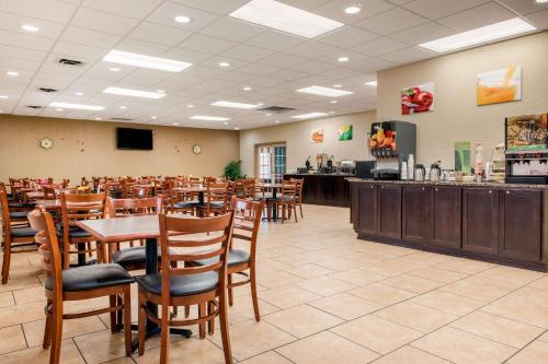 a restaurant with wooden tables and chairs and a bar at Quality Inn in Huntingburg