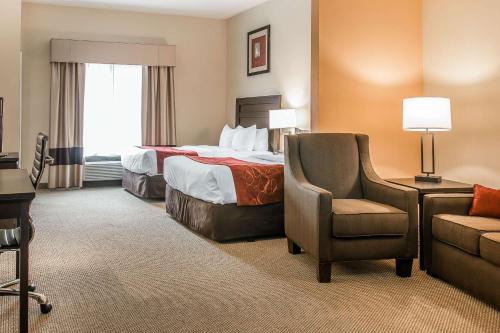 a hotel room with a bed and a chair at Comfort Suites South Bend Near Casino in South Bend