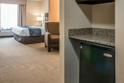 a hotel room with a bed and a room with a refrigerator at Comfort Suites South Bend Near Casino in South Bend