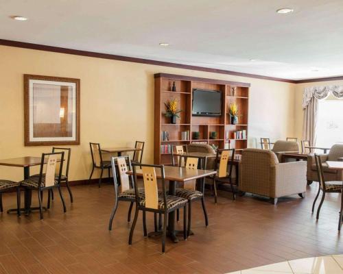 un restaurant avec des tables et des chaises et une télévision à écran plat dans l'établissement Comfort Suites Southport, à Southport