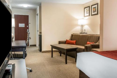 a hotel room with a bed and a couch and a table at Comfort Suites South Bend Near Casino in South Bend