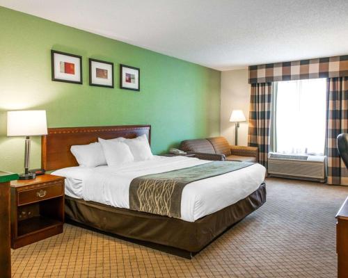 a hotel room with a large bed and a chair at Comfort Inn Goshen in Goshen